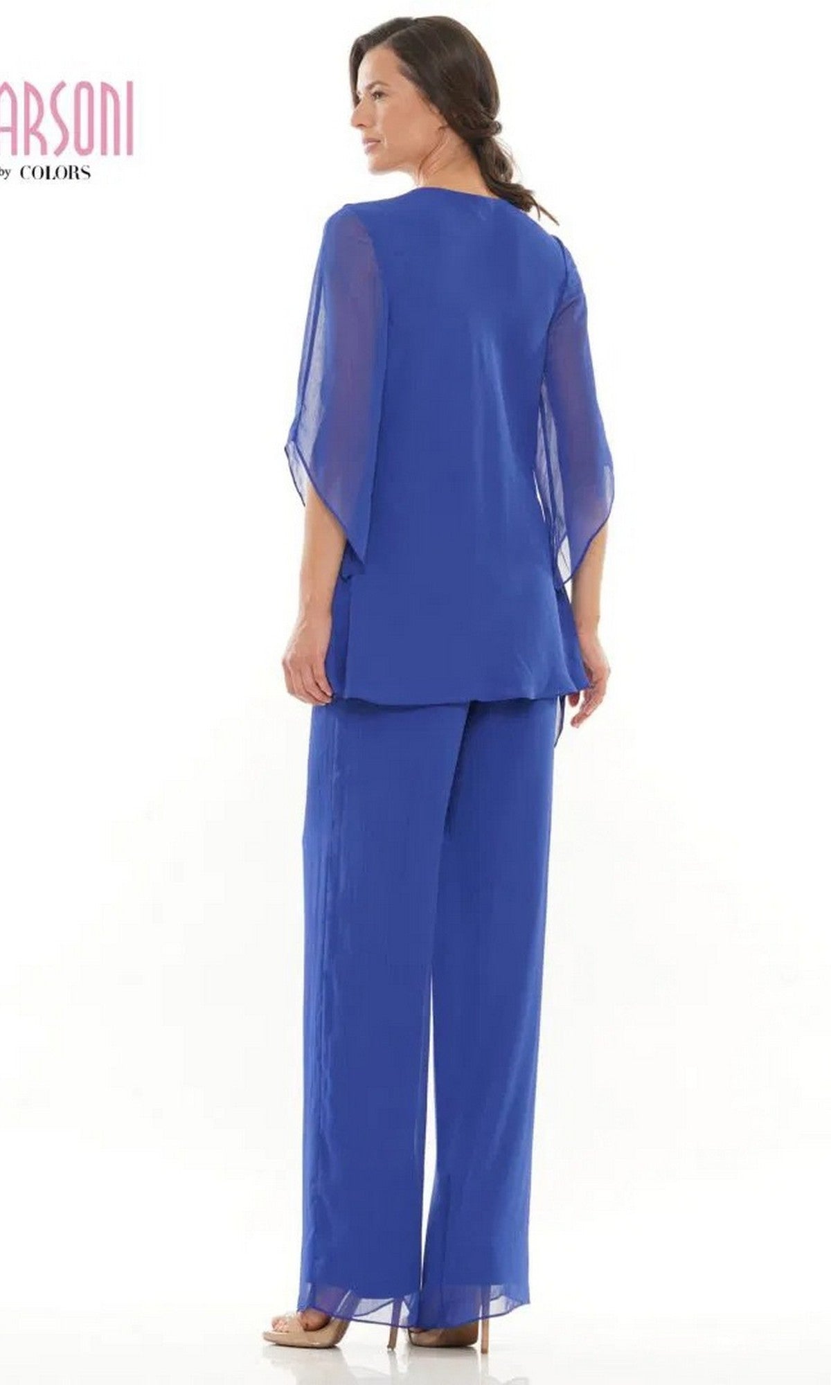 A woman faces away in a royal blue Marsoni M308 Long Formal Pantsuit, featuring sheer sleeves and wide-leg pants, set against a white background.